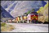 Dash 9 768 leads at the Swarthout Canyon Road xing in Cajon Pass, 2000