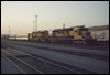 SD40-2s 5107 and 5119 idle with a pair of passenger cars as the sun sets at San Bernardino, CA, 1991