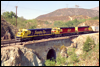 C30-7 8034 and two "Kodachrome" SDs power a westbound at Blue Cut, CA, 1988